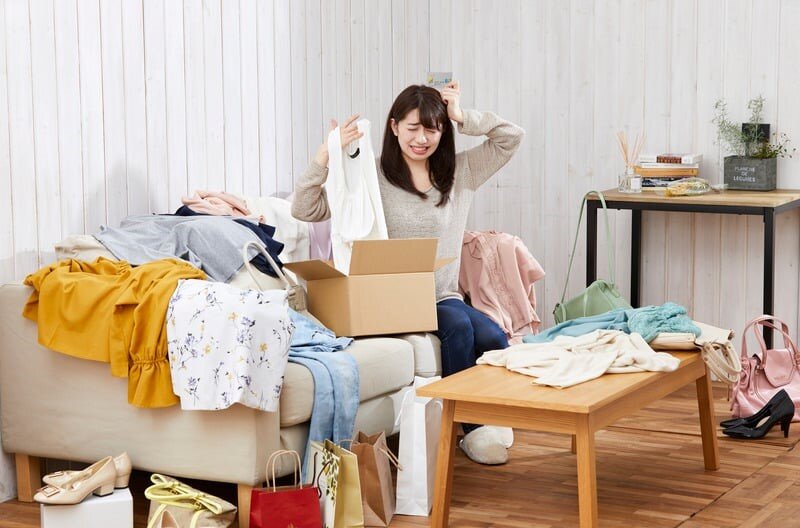 Mantenere l'ordine in casa: come vivere senza caos una donna cerca di riordinare i vestiti sparsi per casa