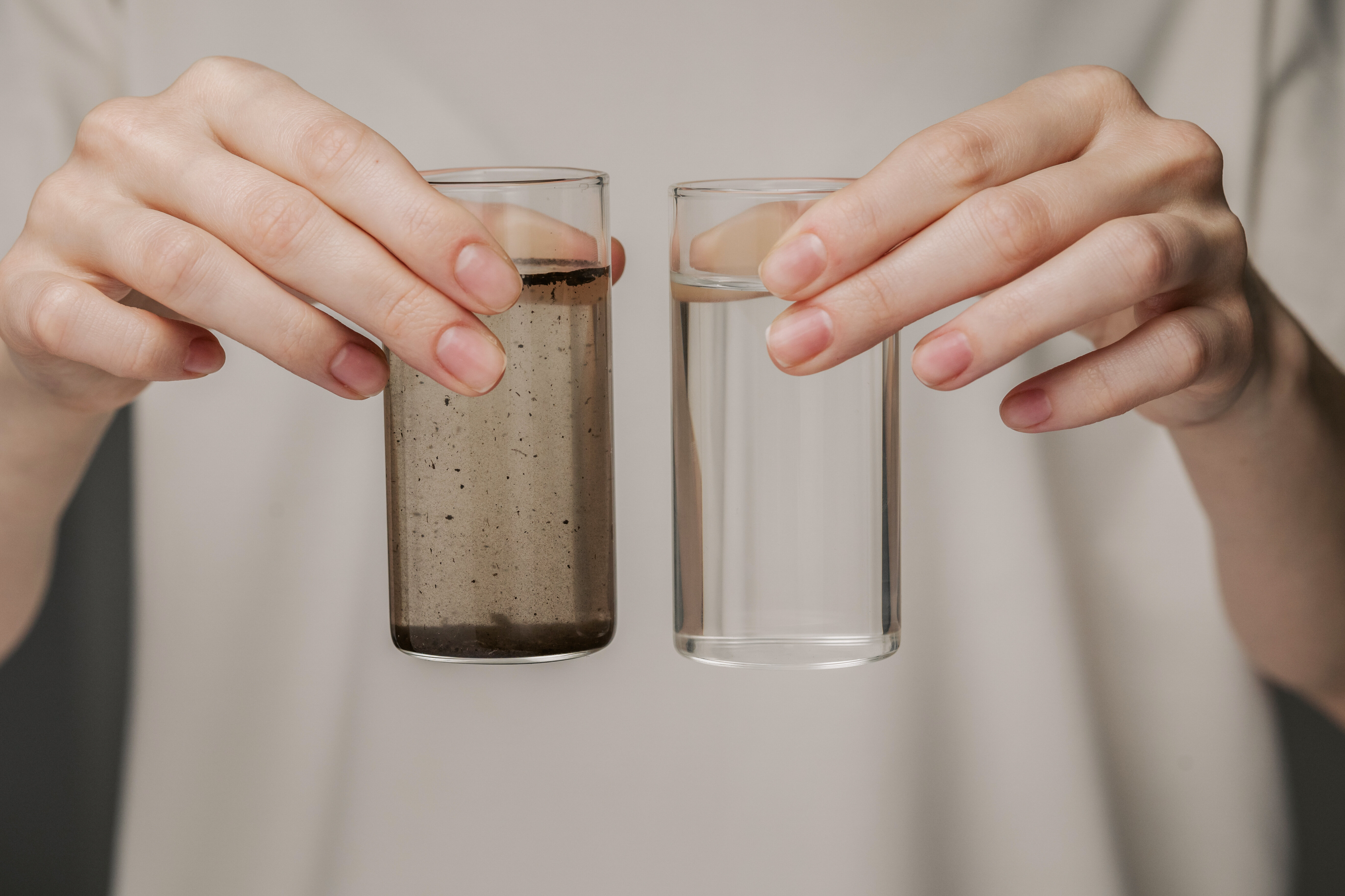 confronto tra due bicchieri uguali di acqua in uno l&#039;acqua pulita nell&#039;altro l&#039;acqua sporca
