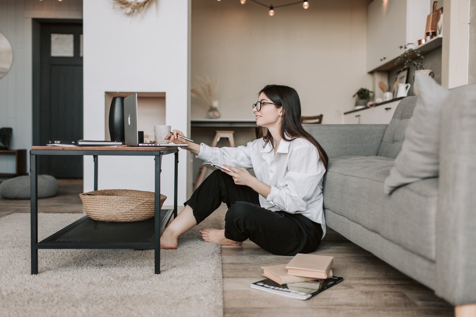 Organizzare casa per lavorare da casa: quando lo stesso spazio deve fare troppe cose una donna lavora da casa seduta per terra