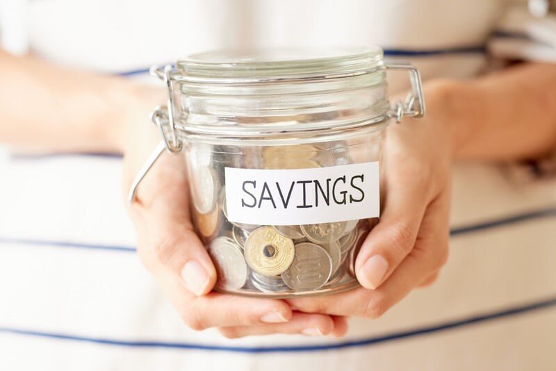 un vasetto pieno di monete con la scritto Savings