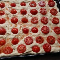 focaccia gotowa do pieczenia. Pomidorki ulozone prawidlowo to te u gory po lewej