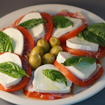 Wersja wzbogacona o plasterki surowej szynki pomiedzy plastrem pomidora i mozzarelli Wersja wzbogacona o plasterki surowej szynki pomiedzy plastrem pomidora i mozzarelli
