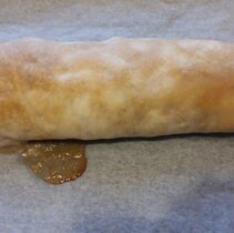 Upieczony strudel; niezbyt dokladne zlepienie ciasta spowodowalo wyciek farszu. Zdarza sie.