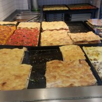 od lewej w glebi: focaggia foggiana, pizza z pomidorami i oliwkami, rozne pizze faszerowane