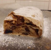 Swiezy, wystudzony, posypany cukrem pudrem i przkrojony strudel.
