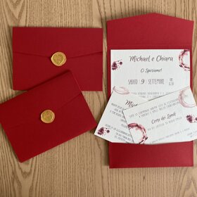 busta in cartoncino colorato con grafica macchie di vino e ceralacca oro