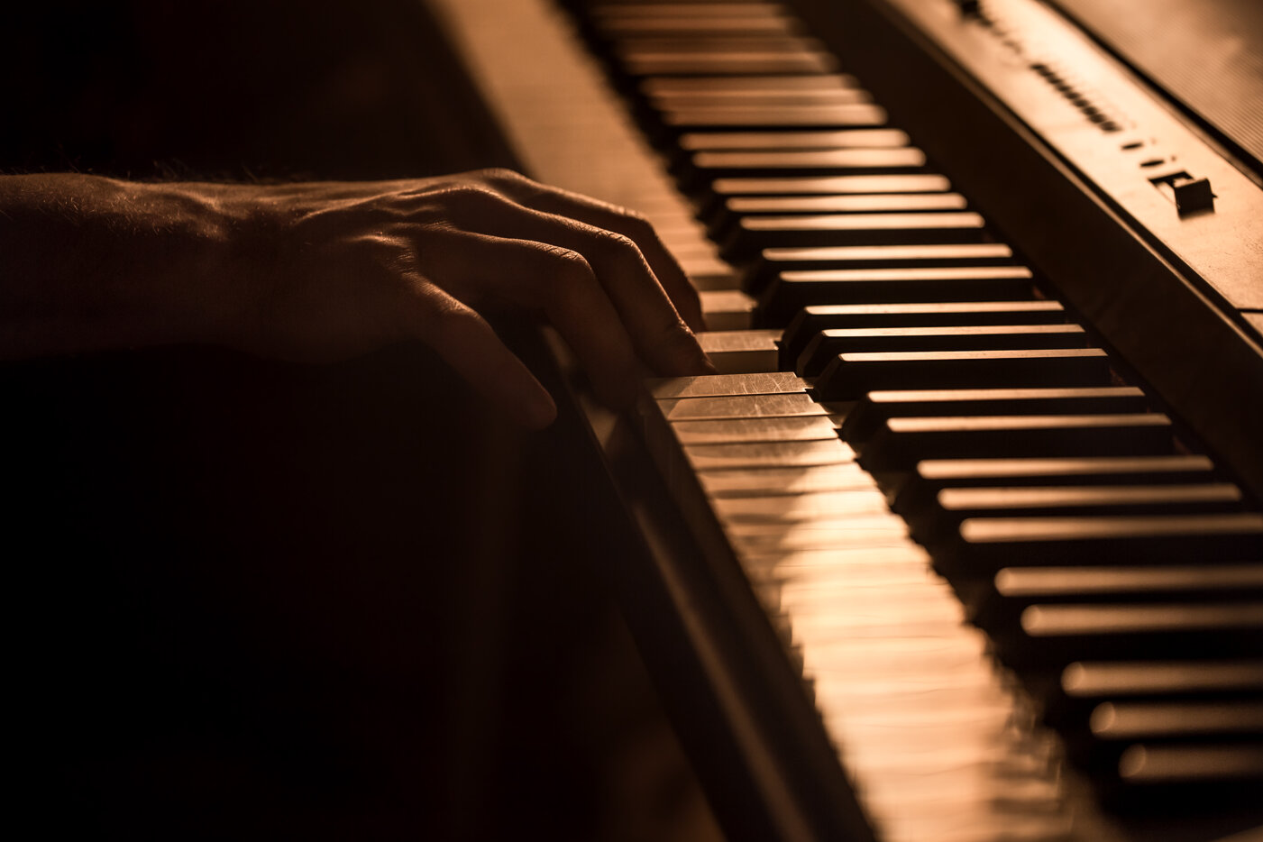 maschio-mani-sui-tasti-del-pianoforte-primo-piano-di-un-bellissimo-sfondo-colorato-il-concetto-di-attivita-musicale.jpeg