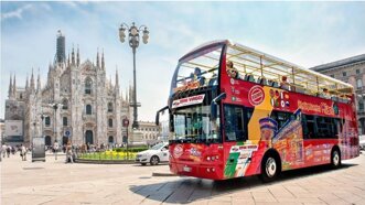 CitySightseeing tourist bus parked in front of Milan Cathedral (Duomo di Milano), showcasing a popular hop-on hop-off tour option in Milan