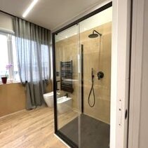 Progetto Interni globale con Ristrutturazione Bagno colorato con box doccia di cristallo con profili in metallo nero
