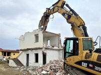 Demolizione Demolizione di fabbricato civile con escavatore attrezzato di pinza