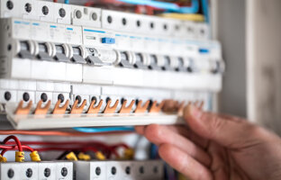 l-uomo-un-tecnico-elettrico-che-lavora-un-quadro-elettrico-con-fusibili-installazione-e-collegamento-di-apparecchiature-elettriche-avvicinamento.jpeg
