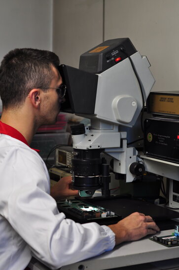 Operatore guarda visore microscopico per schede elettriche Operatore guarda visore microscopico per schede elettriche