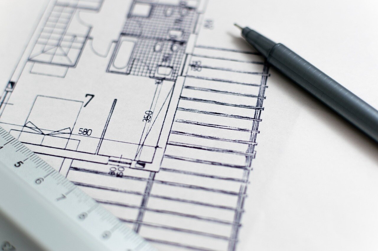 analisi-e-progettazione_foto2.jpeg Architetto che progetta edificio sostenibile con disegni CAD e modelli 3D