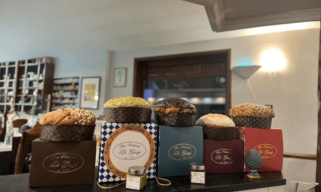 Panettoni artigianali da 1 kg con lievitazione naturale, glassatura dorata e confezioni natalizie