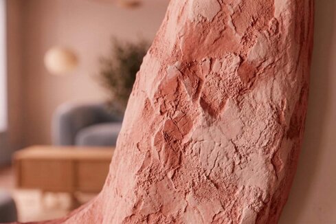 Primo piano della texture materica e scultorea di una cornice per specchiera artigianale. Lavorazione effetto pietra grezza color rosa terracotta, realizzata a mano da Market della Cornice a Verona.