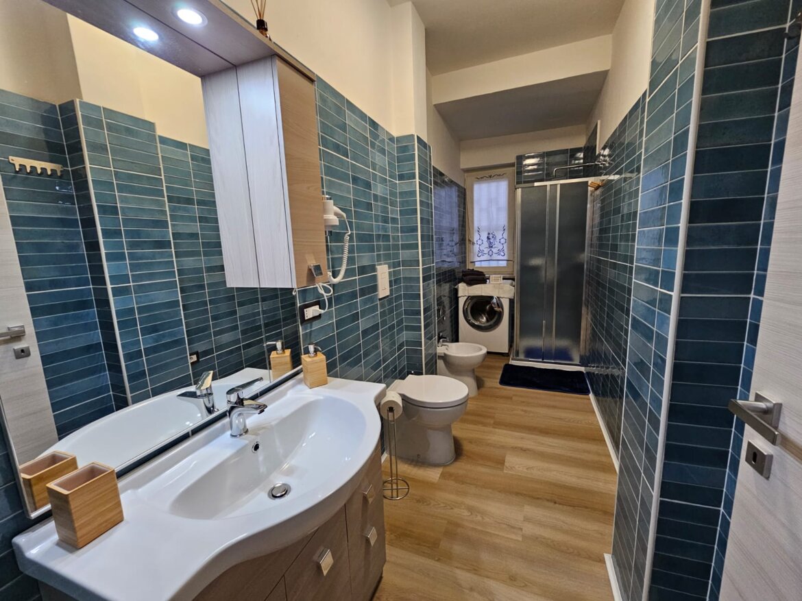 Bagno con cabina doccia, asciugacapelli, lavatrice
