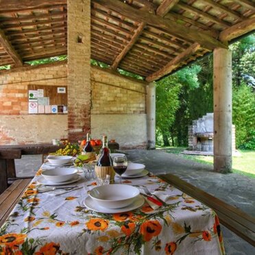 tettoia ad uso comune per il ristoro all'aperto Tettoia esterna aperta su più lati con tavoli per pranzare all'aperto