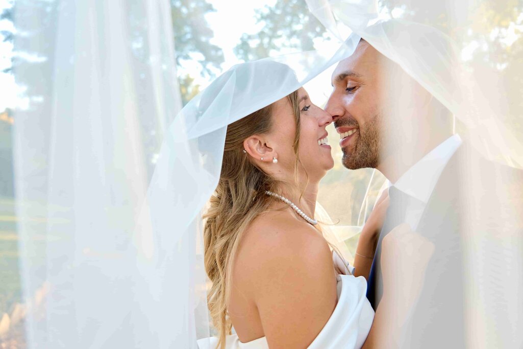 Coppia sotto il velo durante un servizio fotografico di matrimonio