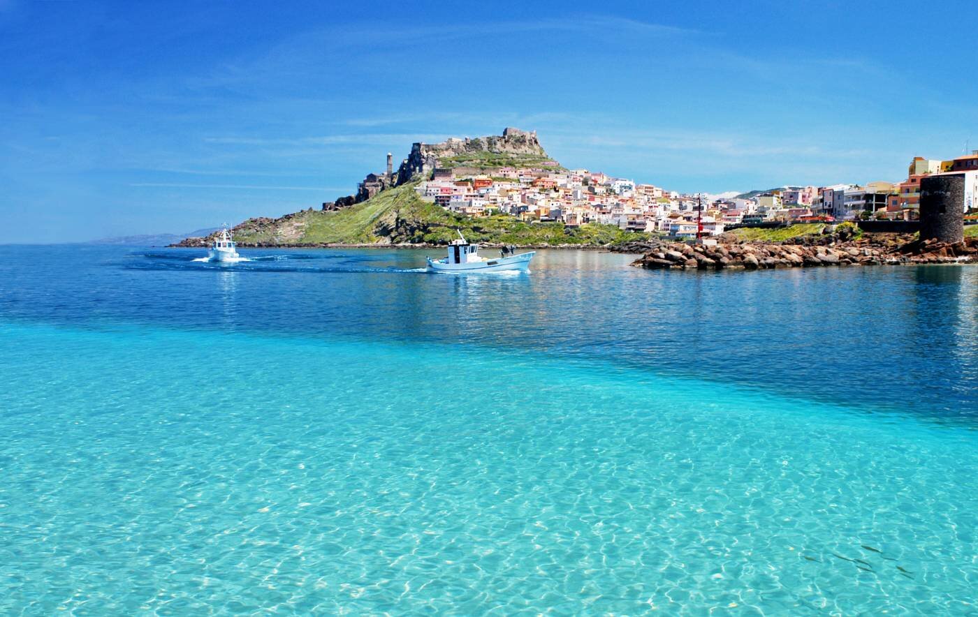 castelsardoporto.jpeg splendita foto di castelsardo visto dal porto turistico con mare cristallino che si confonde nel cielo