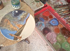 Dettaglio della lavorazione a terzo fuoco su piatto in porcellana con decoro artistico e tavolozza colori, laboratorio Porcellane Carusio.