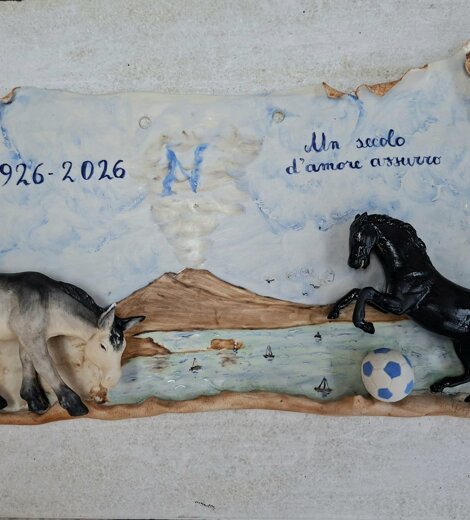 Pergamena in porcellana di Capodimonte creata da Porcellane Carusio per il centenario del Calcio Napoli (1926-2026), con bassorilievi del ciuccio, del cavallo nero, del Vesuvio e del golfo.