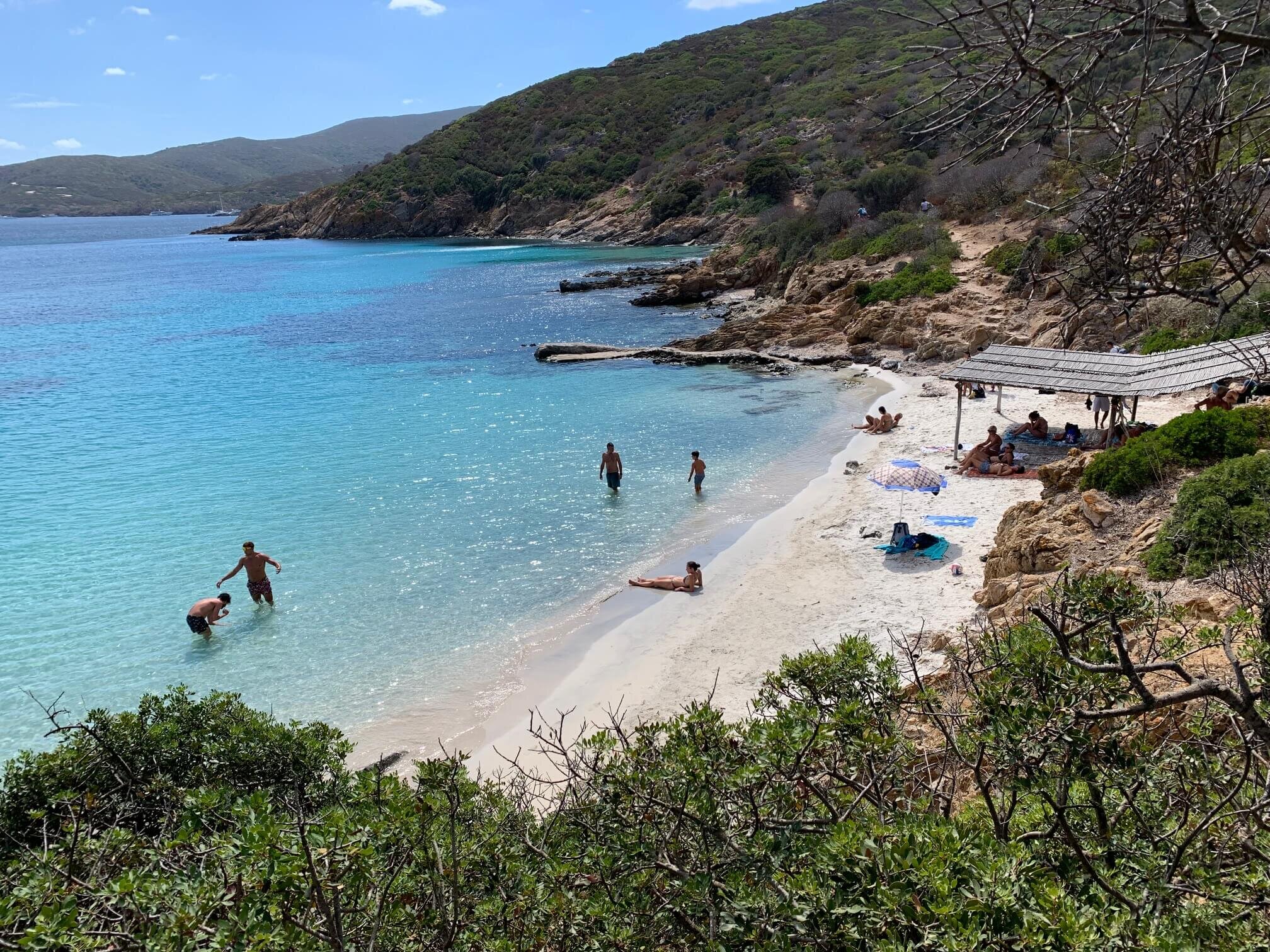 Caletta nascosta all'Asinara con sabbia bianchissima e acqua verde smeraldo.