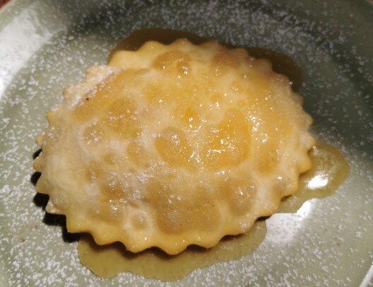 seadas-al-miele-vecchio-mulino-sassari-villa-malvasio.jpeg Tradizionale seada sarda ricoperta di miele dorato, il classico dolce artigianale servito al ristorante Il Vecchio Mulino a Sassari.