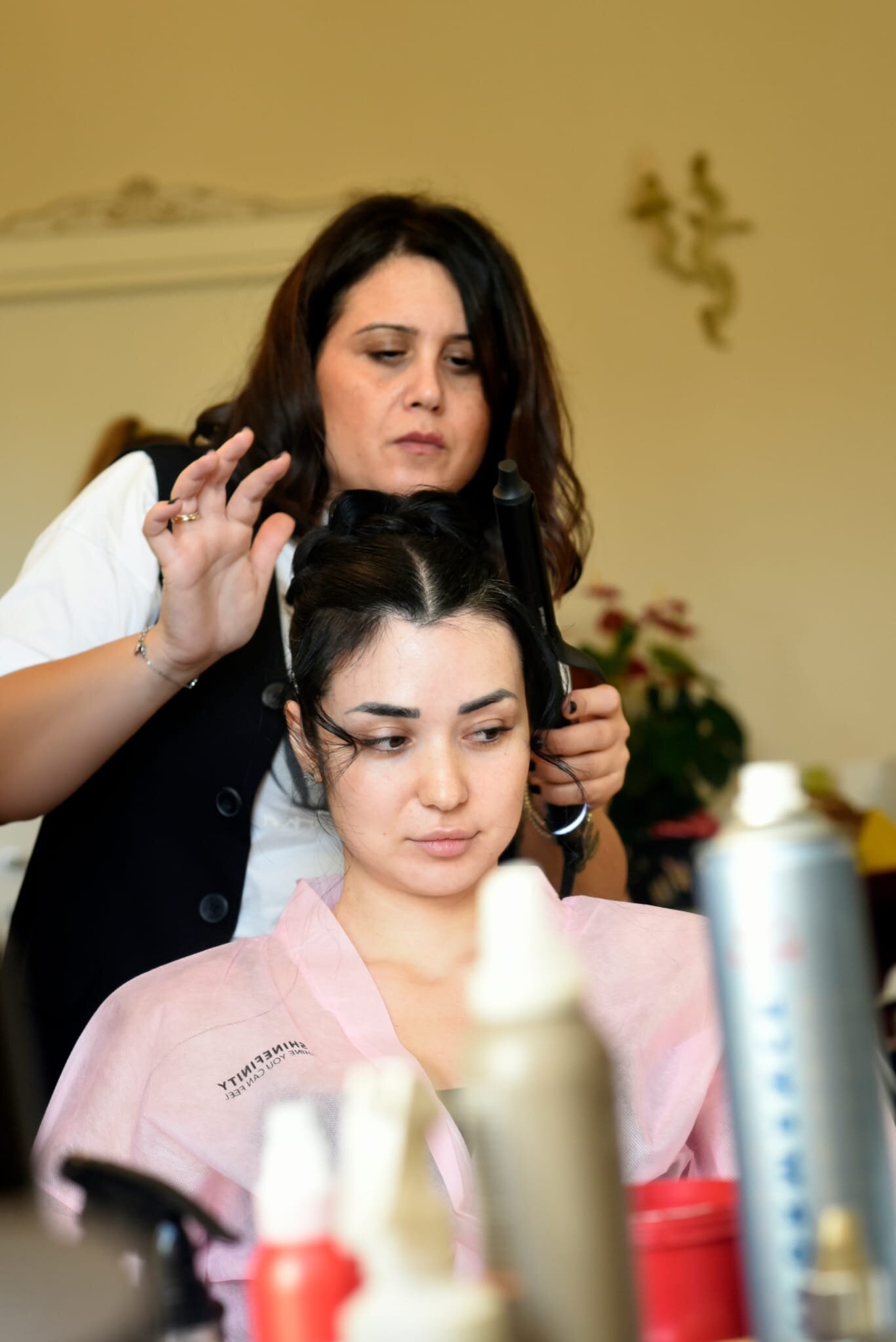 Laura di Parrucchiera Vera Evolution al lavoro per valorizzare la elegante acconciatura sposa della modella Arianna Bianco nella camera di Villa Malvasio