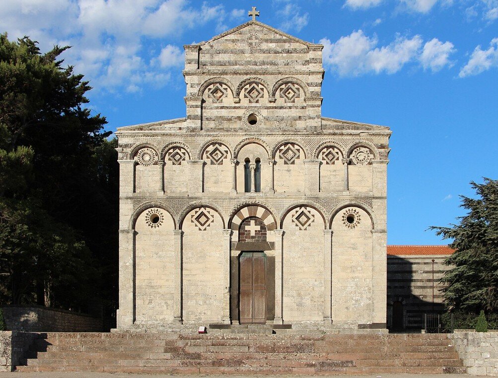 san-pietro-di-sorres-sardegna.jpeg Fotografia diurna reale della facciata dell’ex cattedrale di San Pietro di Sorres a Borutta. L’immagine mostra la splendida architettura romanica caratterizzata dalla bicromia di pietre calcaree chiare e basaltiche scure.