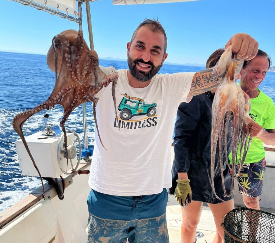 Un cliente soddisfatto mostra due polpi appena pescati con le nasse tradizionali durante una giornata di pescaturismo a Stintino.