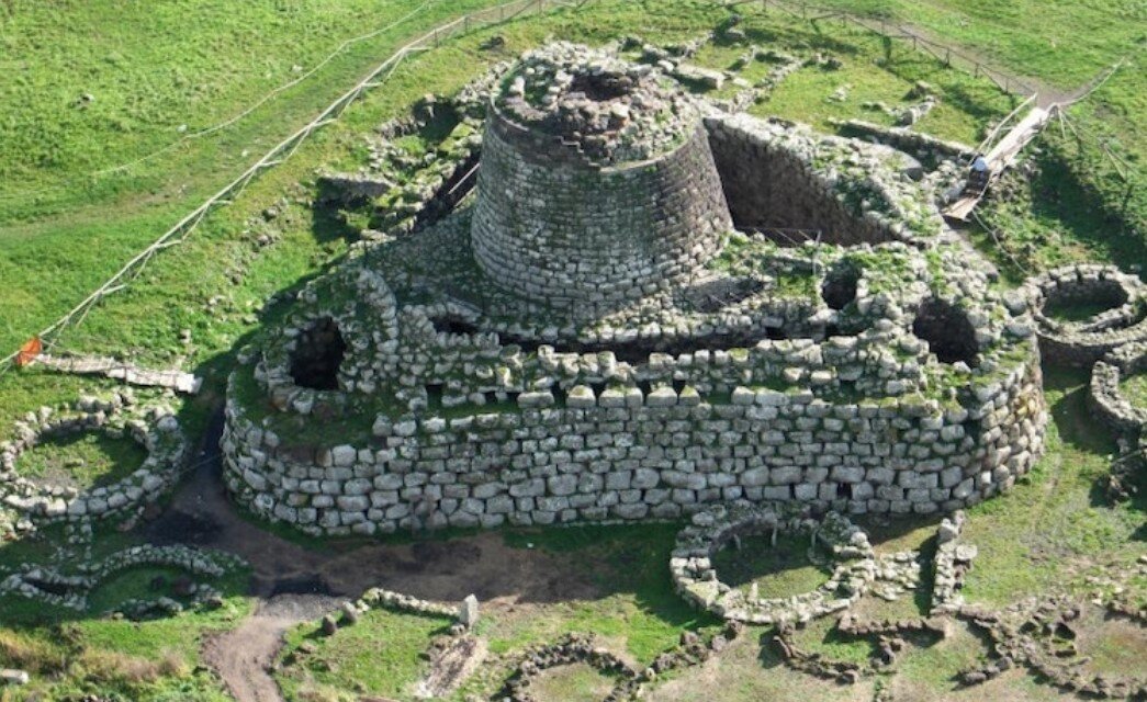 Fotografia aerea del Nuraghe Santu Antine a Torralba. La vista dall’alto evidenzia la perfetta pianta a forma di triangolo equilatero, il maestoso mastio centrale e i resti del villaggio nuragico circostante.
