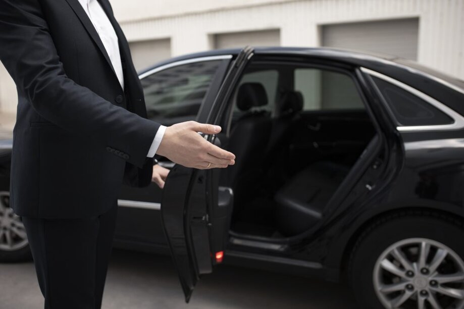 uomo-elegante-in-piedi-accanto-alla-sua-auto-per-i-servizi-di-taxi-1024x683.jpeg