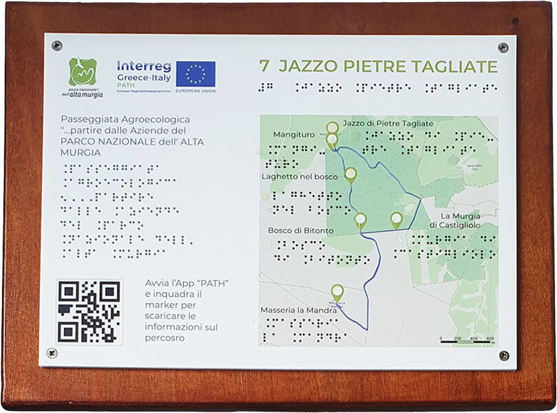 in quadricromia e Braille. Immagine a rilievo, con loghi e QR-code. Piantana in legno.