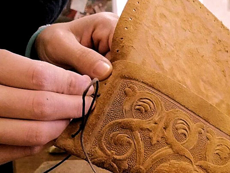 Dettaglio della tecnica di cucitura a mano con cordino cerato Dettaglio della tecnica di cucitura a mano con cordino cerato