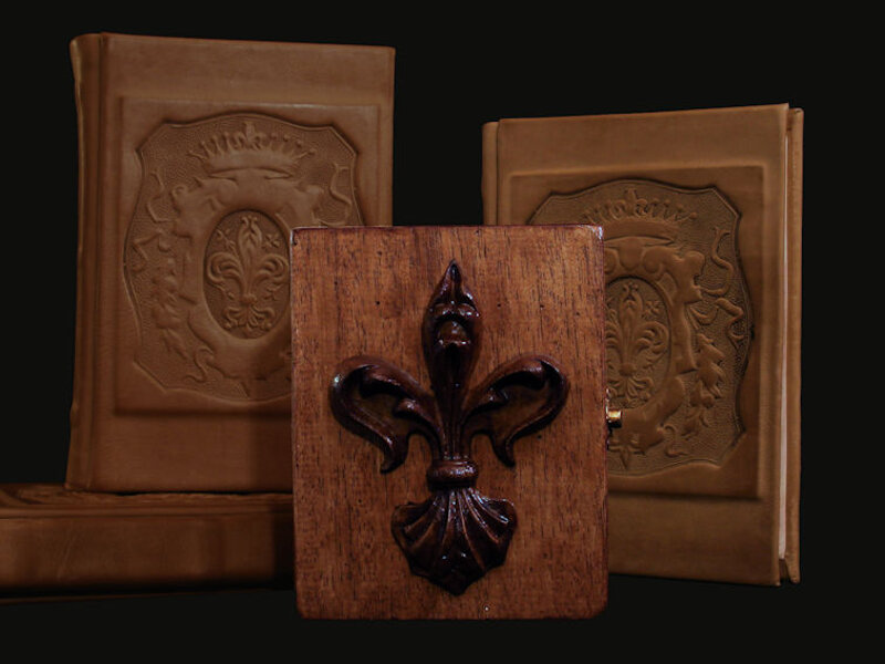 Scatola invecchiata con il giglio di Firenze invecchiato e lucidato sullo sfondo di quaderni pelle