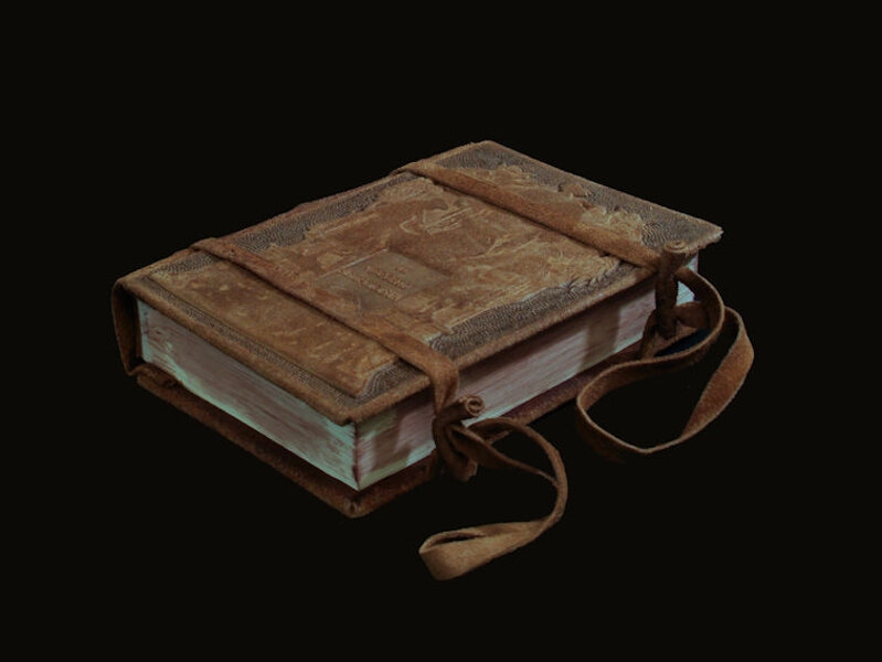 Quaderno in pelle grigia con due lacci di pelle che lo chiudono