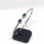 amedeo-design-bracciale-rigido-in-oro-bianco-incastonante-diamanti-e-due-smeraldi-a-goccia