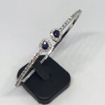 amedeo-design-bracciale-rigido-in-oro-bianco-incastonante-diamanti-e-due-zaffiri-blu-a-goccia