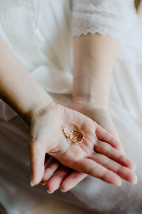 Sposa con fedi nuziali tra le mani durante matrimonio elegante