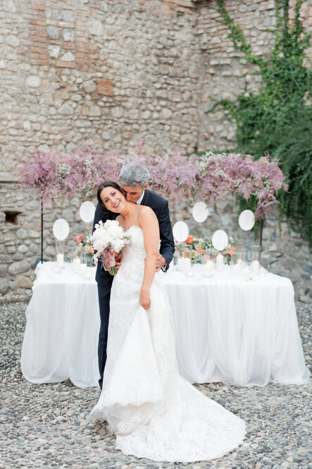 Sposi in abiti eleganti si baciano durante matrimonio esclusivo Sposi in abiti eleganti si baciano durante matrimonio esclusivo