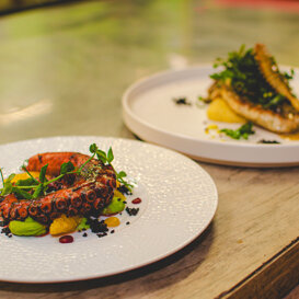 Polpo e calamaro su piselli e filetto di rombo in salsa di capperi con polenta