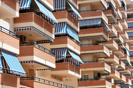 502050896-facade-of-apartment-building-with-balconies-and-awnings