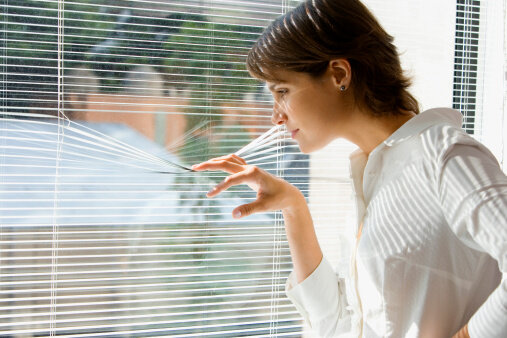 80615200-businesswoman-looking-out-office-window