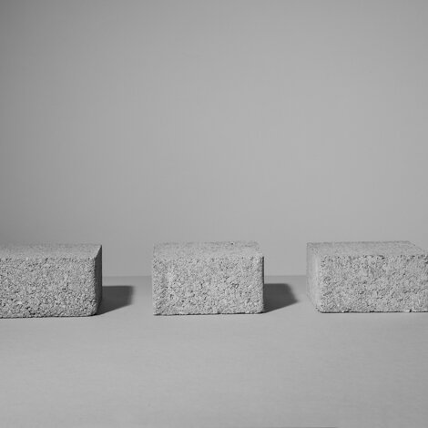 Still life con tre elementi in cemento grezzo su fondo grigio