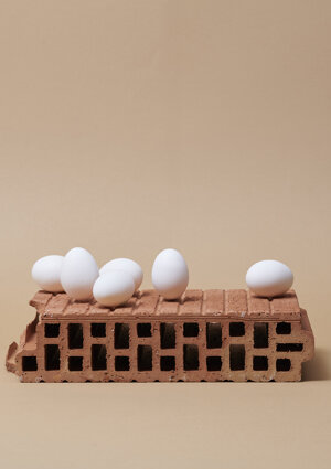 Still life di uova bianche disposte su un mattone