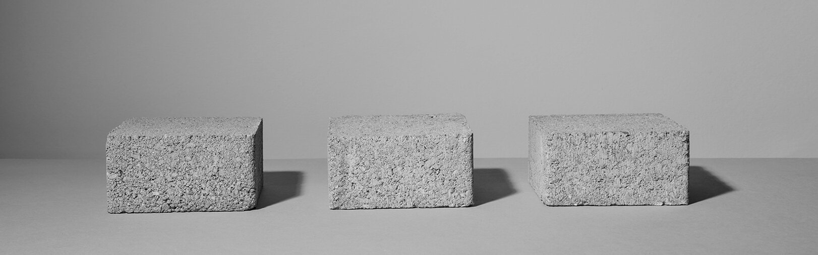 Still life con tre elementi in cemento su fondo grigio