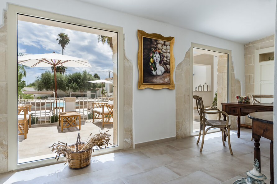 Interno luminoso con vista sul verde mediterraneo e sulla piscina 