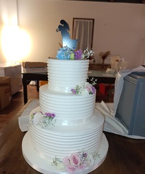 Torta bianca a piani delicata con fiori bianchi e lilla