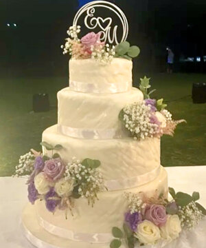 Torta a piani in pasta di zucchero con ciufetti di fiori freschi