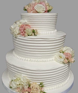 Torta bianca a piani delicata con fiori bianchi e rosa